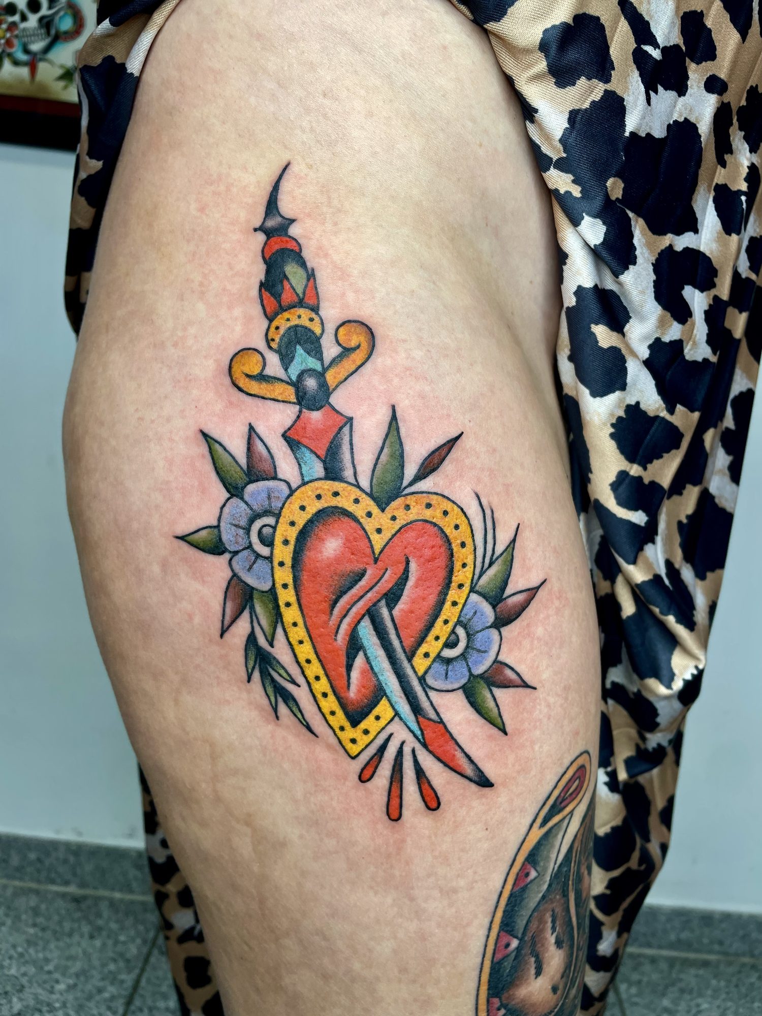 Herz mit Dolch und Blüten am Oberschenkel, Blumen Tattoo von Jill bei Eine Liebe Tätowiergeschäft in Bochum