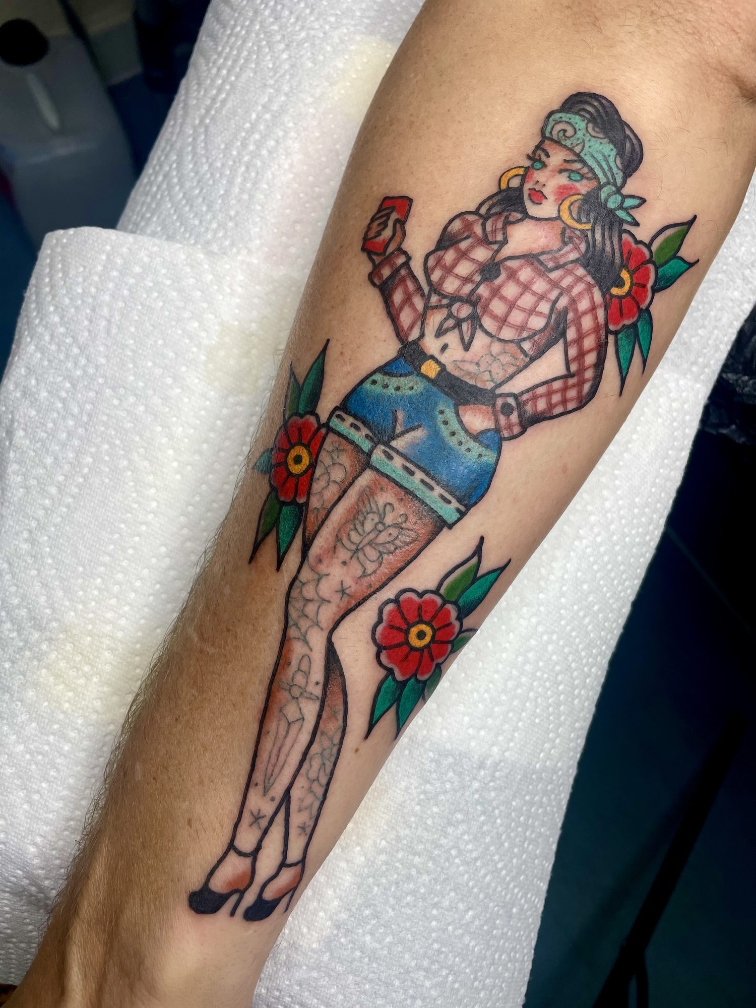 Pin-up-Girl in Jeansshorts am Unterarm, Pin-up Tattoo von Jill bei Eine Liebe Tätowiergeschäft in Bochum