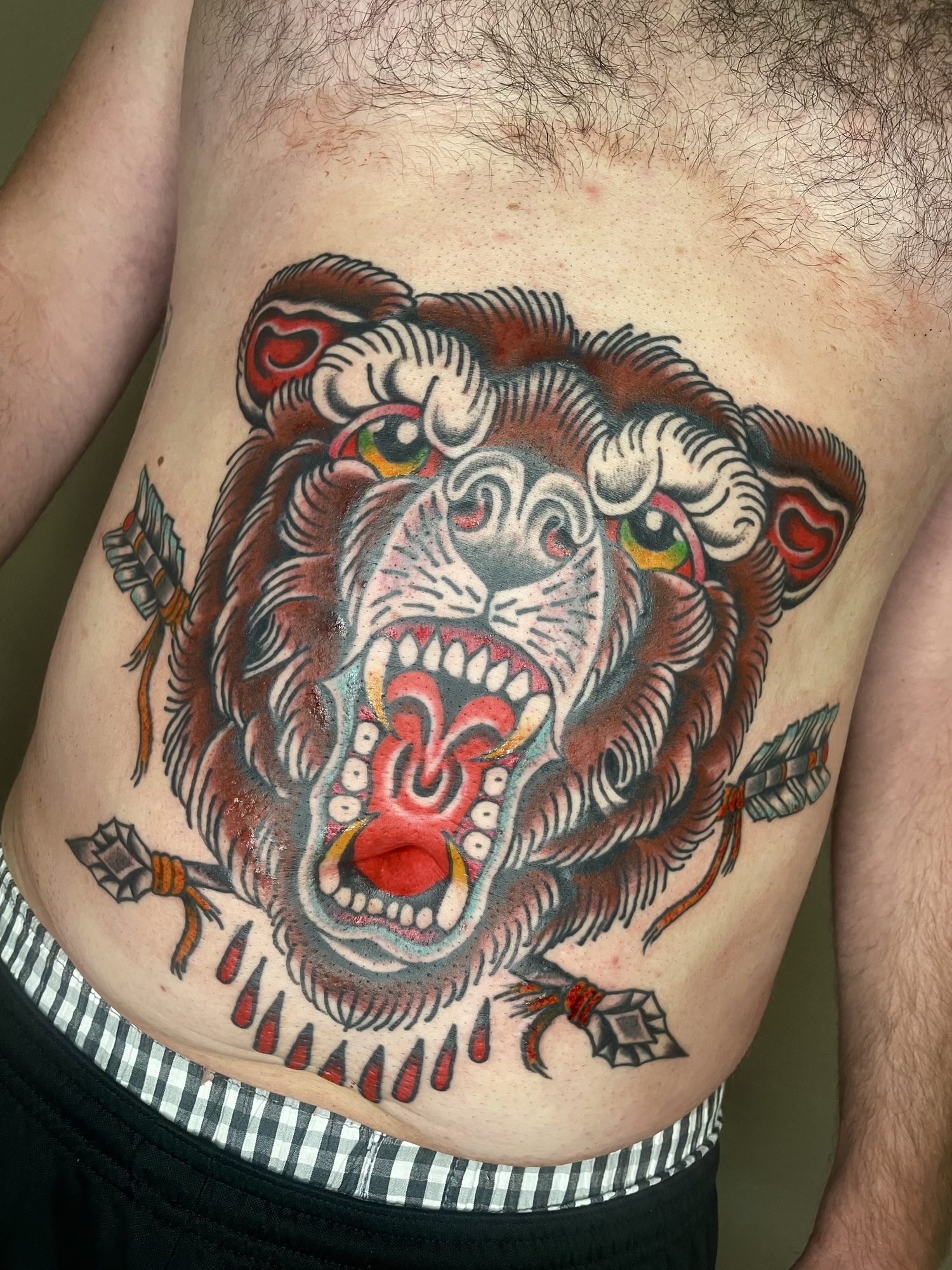 Bärenkopf mit Pfeilen am Bauch, Traditional Tattoo von Jill bei Eine Liebe Tätowiergeschäft in Bochum